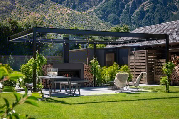 outdoor entertaining area with an outdoor fireplace in Queenstown 